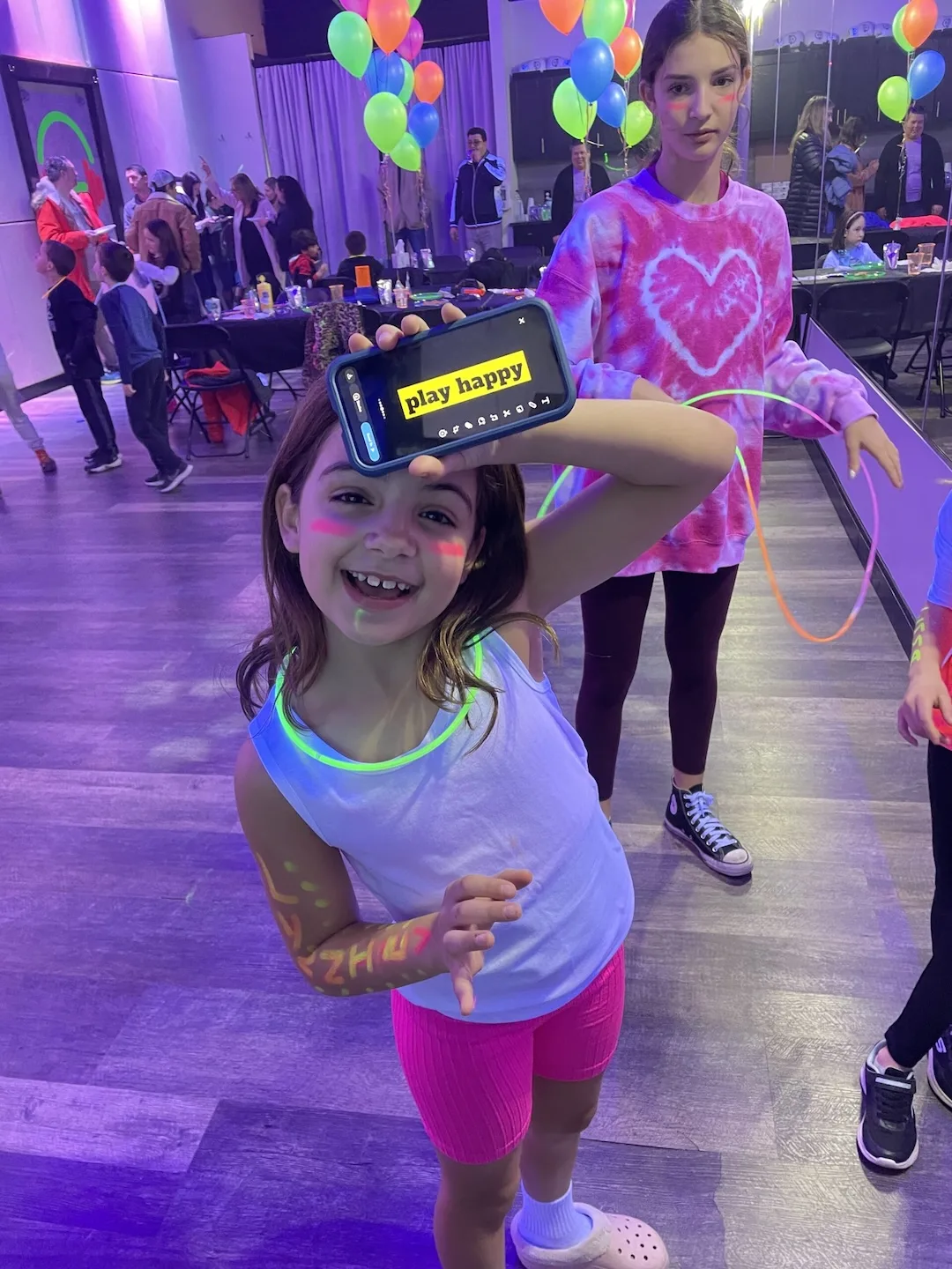 A smiling child enjoying a neon party at DJ Got Me Fit